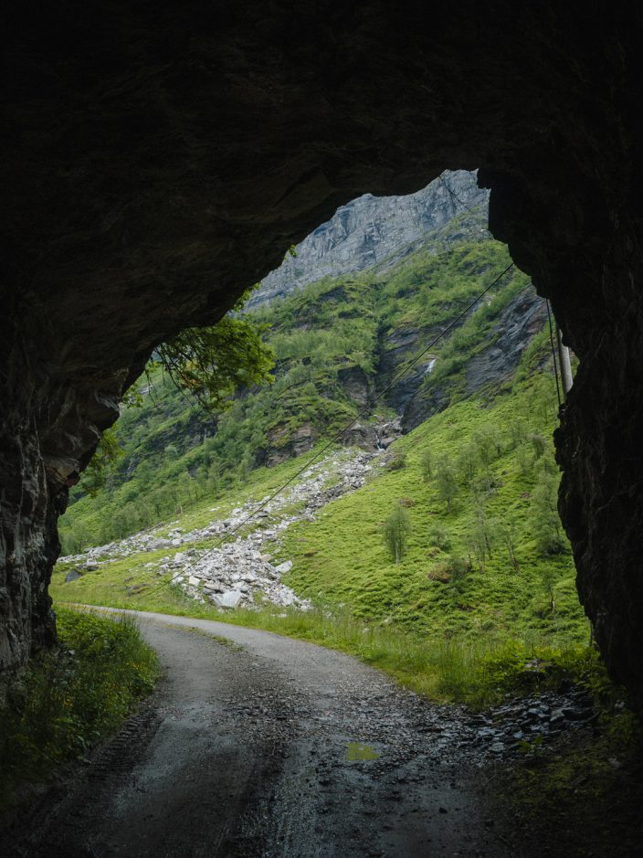 Getting out of a pitch black tunnel. Poor standard, gravel road, view out of a tunnel