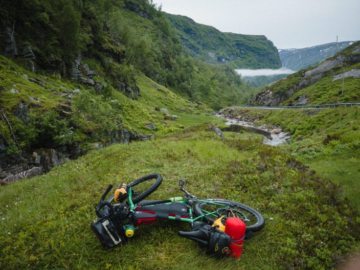Camping spot, Fargo all packed and ready for descent. touring bicycle laying on grass, next to road