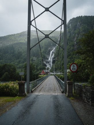 In the village Mo in Modalen, under a grey blanket. one way bridge, waterfall in the background, rainy day.