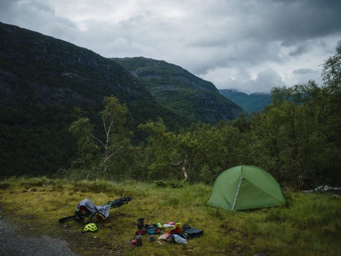 Packing and drying. Well, packing at least. bicycle, camping equipment and tent next to a gravel road